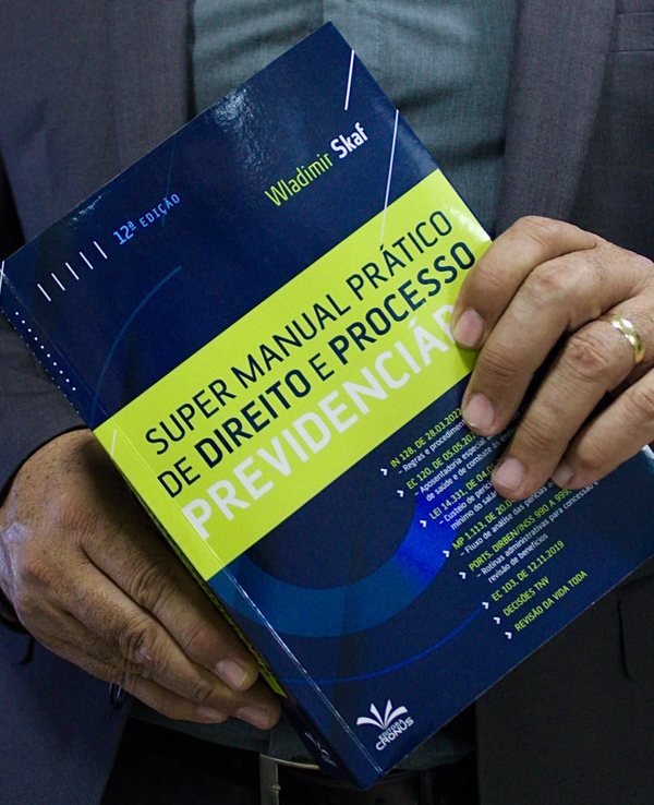Dr. Wladimir Skaf segurando o livro Super Manual Prático de Direito e Processo Previdenciário, 12ª edição